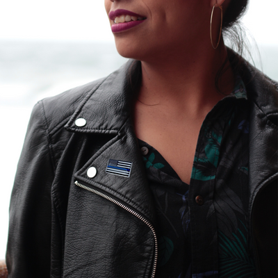 woman wearing leather jacket win thin blue line flag on lapel