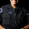 female officer smiling and wearing a police lapel pin