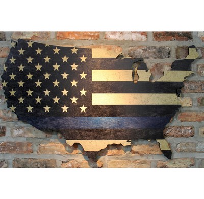 thin blue line flag on wood hanging on brick wall with light shining